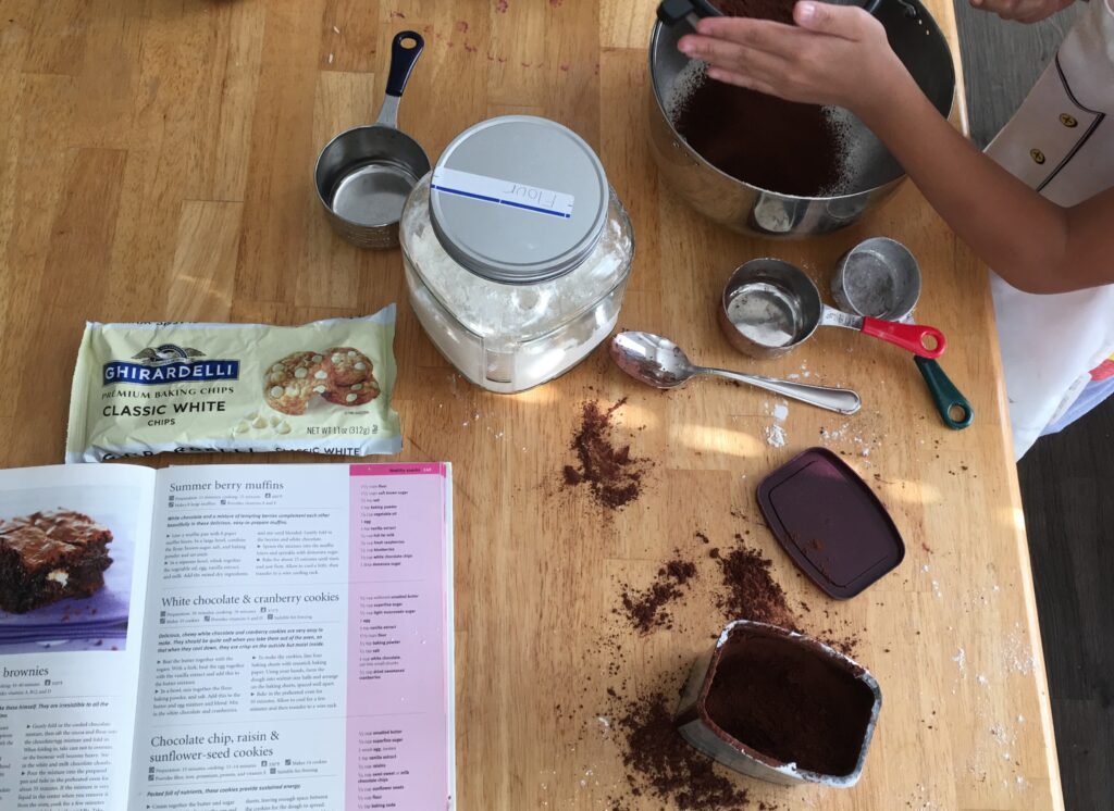 A messy kitchen table with ingredients for brownies. 